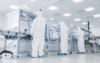 Manufacturing facility team of scientists wearing sterile protective coverall