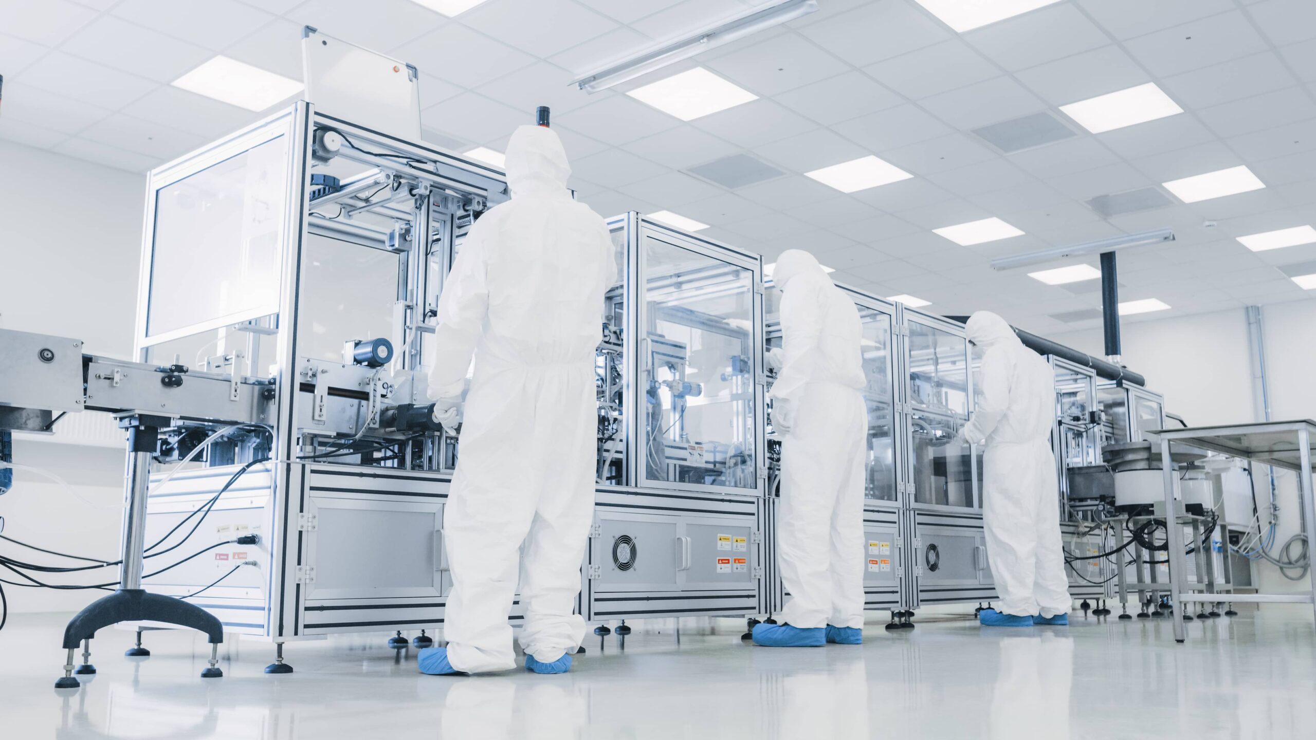 Manufacturing facility team of scientists wearing sterile protective coverall