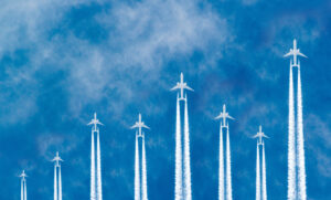 Airplanes flying in parallel in the blue sky forming a stock market curve graph.